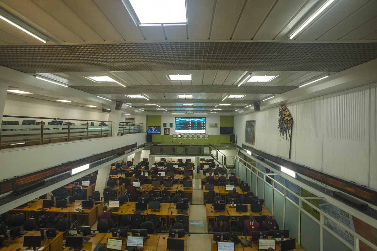 מבט מעל אולם מסחר בבורסה עם עמדות סוחרים ומסכים