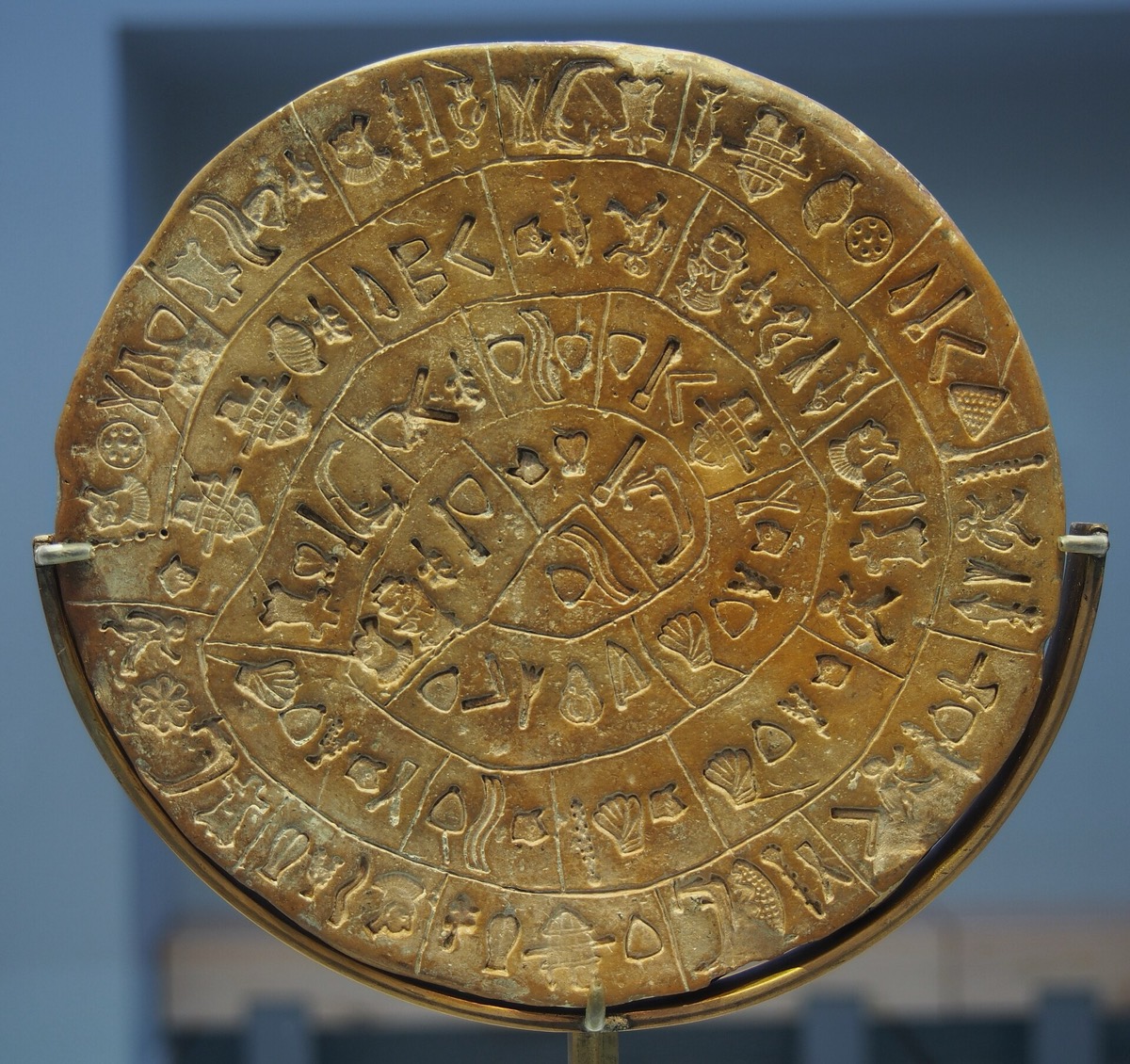 דיסקת חרס עגולה ועליה שורות ספירליות צפופות של סמלים מוטבעים